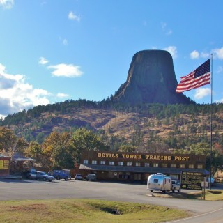 Devils Tower National Monument. - Fahne, Gebäude, Flagge, Sehenswürdigkeit, Landschaft, Berg, Monolith, Post Office, Devils Tower, Devils Tower National Monument, Wyoming, Attraktion, Teufelsturm, Vulkangestein, Wohnwagen, Trading Post - (Devils Tower, Wyoming, Vereinigte Staaten)