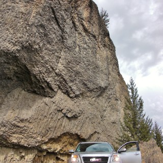 Yellowstone-Nationalpark. Overhanging Cliff, Tower-Roosevelt - Yellowstone-Nationalpark. - Auto, Felsen, Felsformation, Felswand, Stein, GMC, GMC Terrain, PKW, Tower-Roosevelt, Overhanging Cliff, Basalt - (Devils Den, Yellowstone National Park, Wyoming, Vereinigte Staaten)