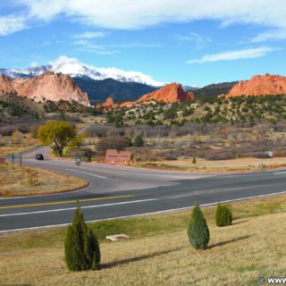 Garden of the Gods. Aussicht vom Besucherzentrum des Garden of the Gods Park. Im Hintergrund sieht man den schneebedeckten Gipfel des Pikes Peak auf den das bekannte Bergrennen Pikes Peak International Hill Climb oder auch Race to the Clouds genannt, ausgetragen wird. Die rötlich gefärbten Sandsteinformationen im Vordergrund sind Kindergarten-, South Gateway- und North Gateway Rock (v.l.n.r).. - Sehenswürdigkeit, Landschaft, Panorama, Sandstein, Sandsteinformationen, Park, Ausflugsziel, Garten der Götter, Naturpark, sehenswert, Kindergarten Rock, North Gateway Rock, Pikes Peak, South Gateway Rock - (Glen Eyrie, Colorado Springs, Colorado, Vereinigte Staaten)